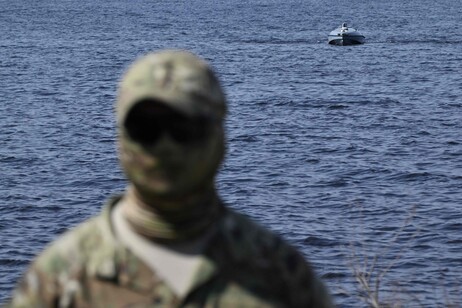 A Ukrainian serviceman stands near a Magura V5