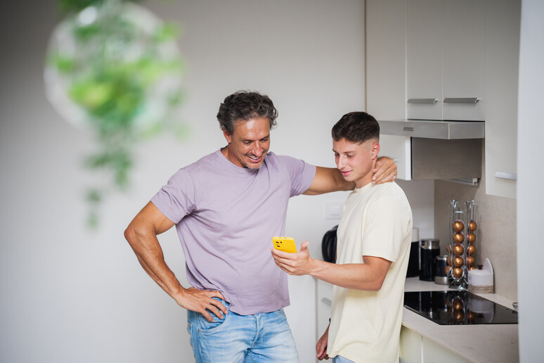 Un figlio mostra al padre lo smartphone foto iStock. - RIPRODUZIONE RISERVATA